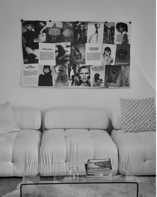 Canapé bas et planche d'images noir et blanc punaisée au mur